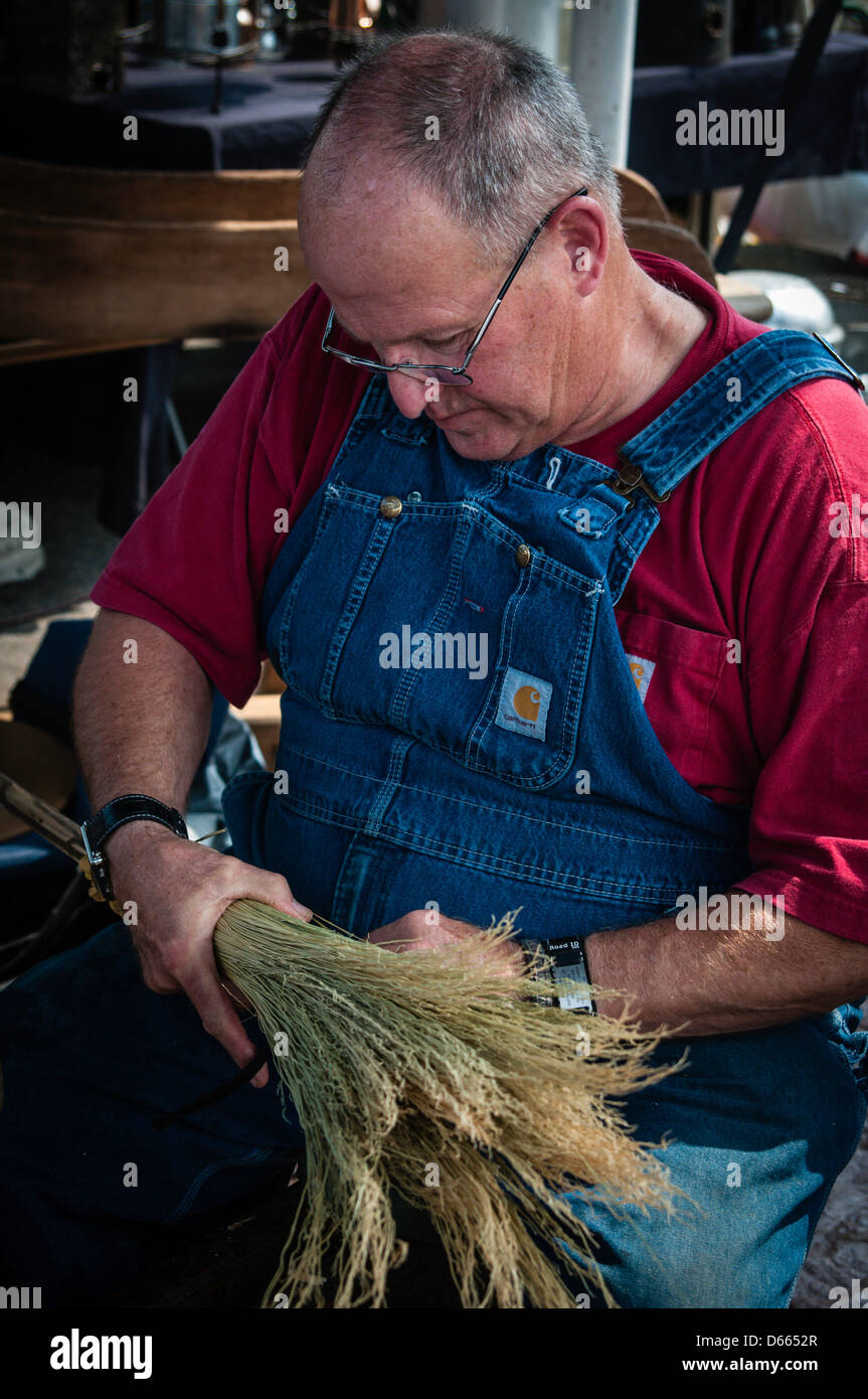 Craftsman assembling handmade brooms. Stock Photo