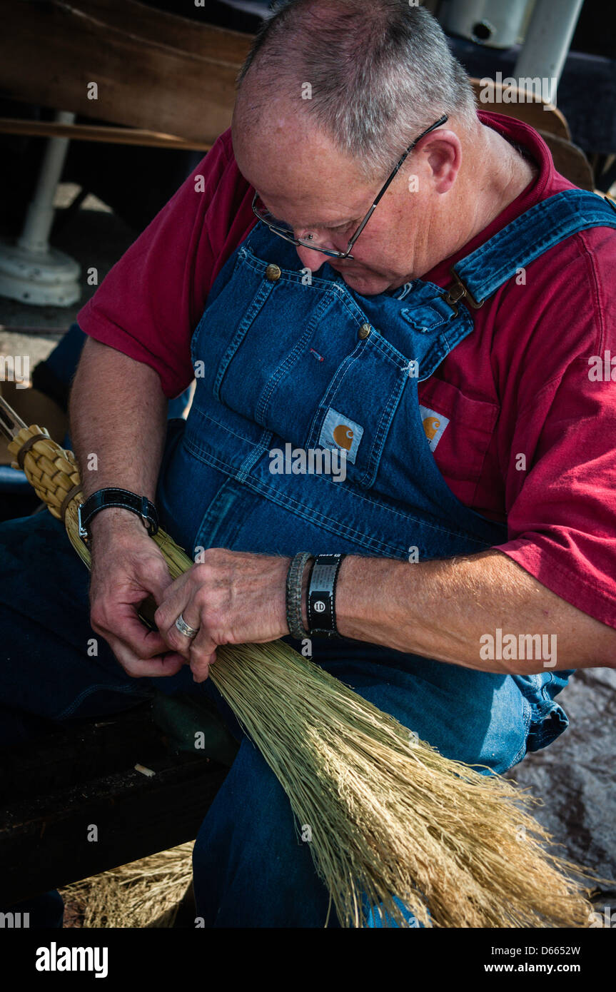 Craftsman assembling handmade brooms. Stock Photo