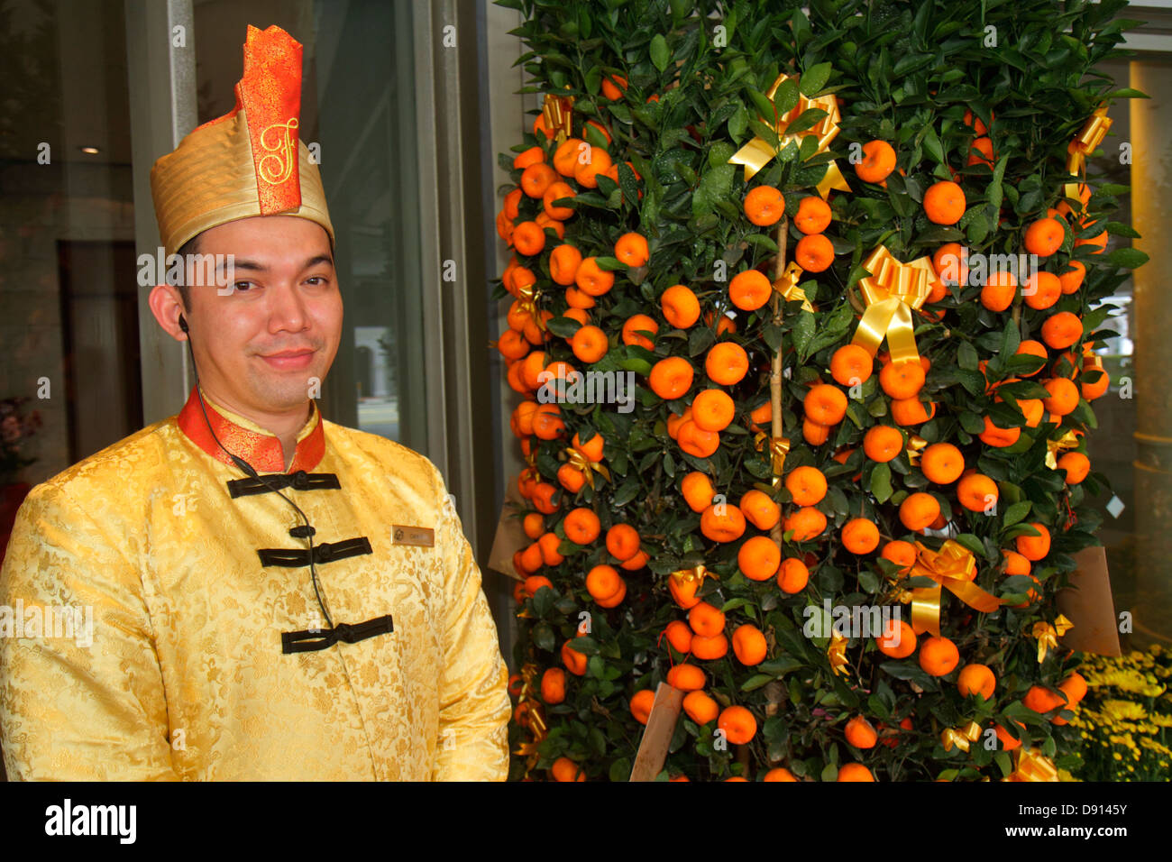 Singapore,Fairmont Singapore,hotel,lobby,doorman,uniform,Asian man men male,employee worker workers working staff,Mandarin orange tree,tangerine,Chine Stock Photo