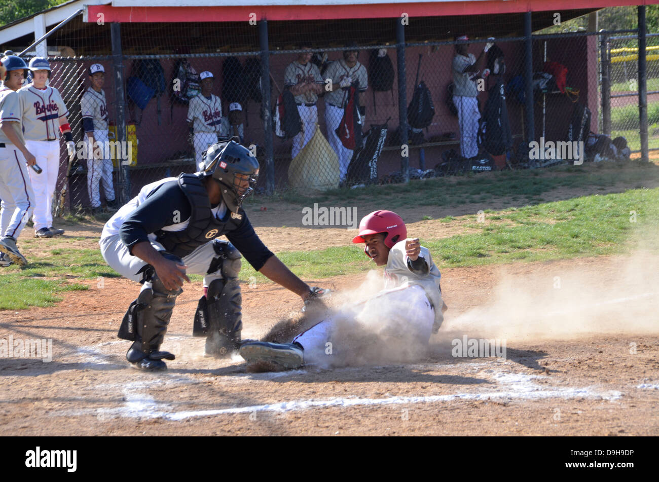 sliding into home base in a high school baseball game Stock Photo