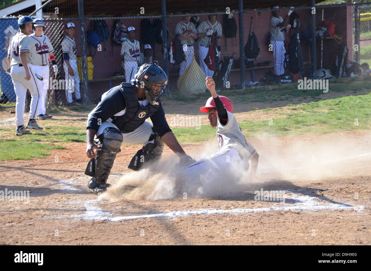 sliding into home base in a high school baseball game Stock Photo