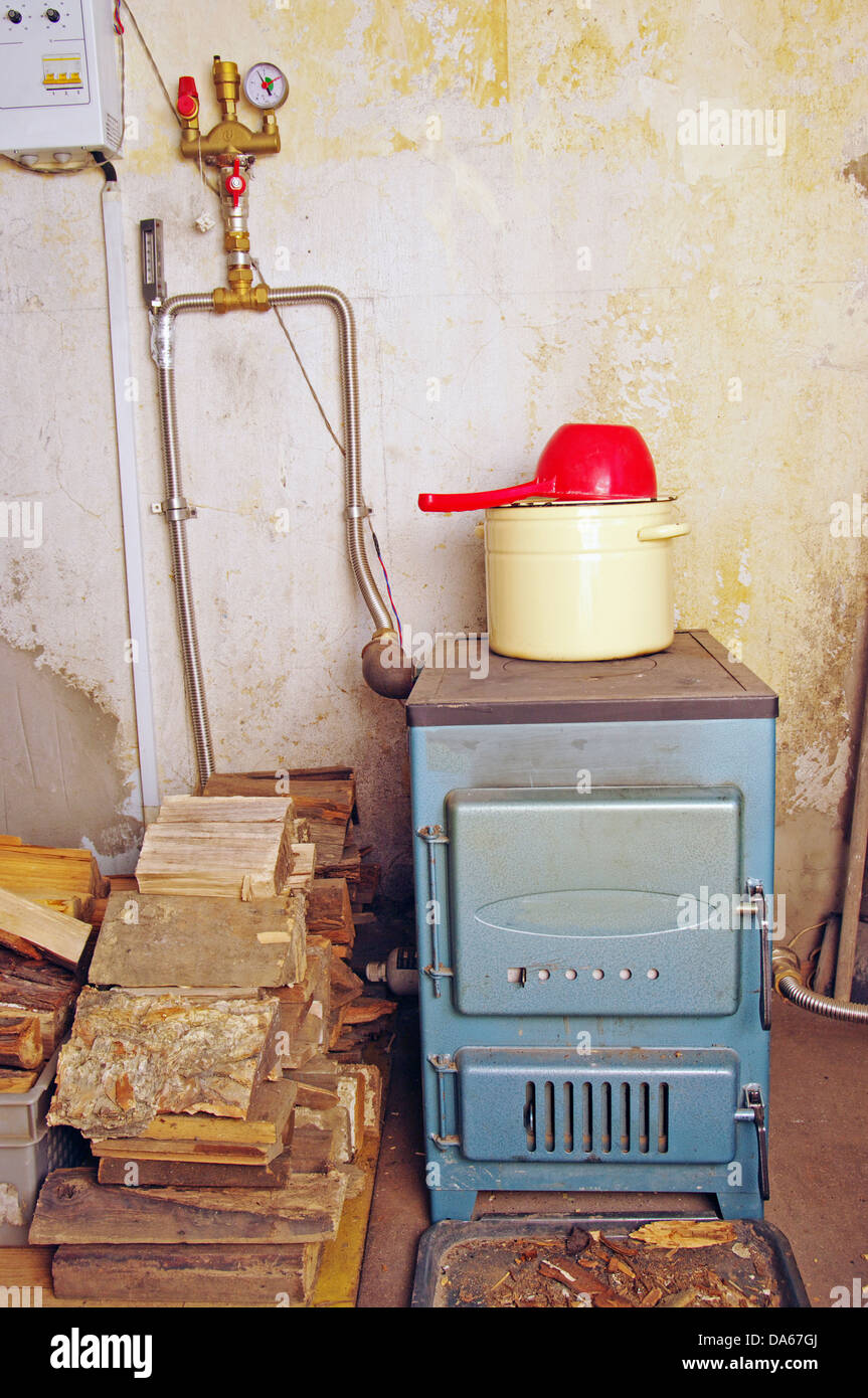 steel water boiler with a stove plate pan and ladle at home Stock Photo