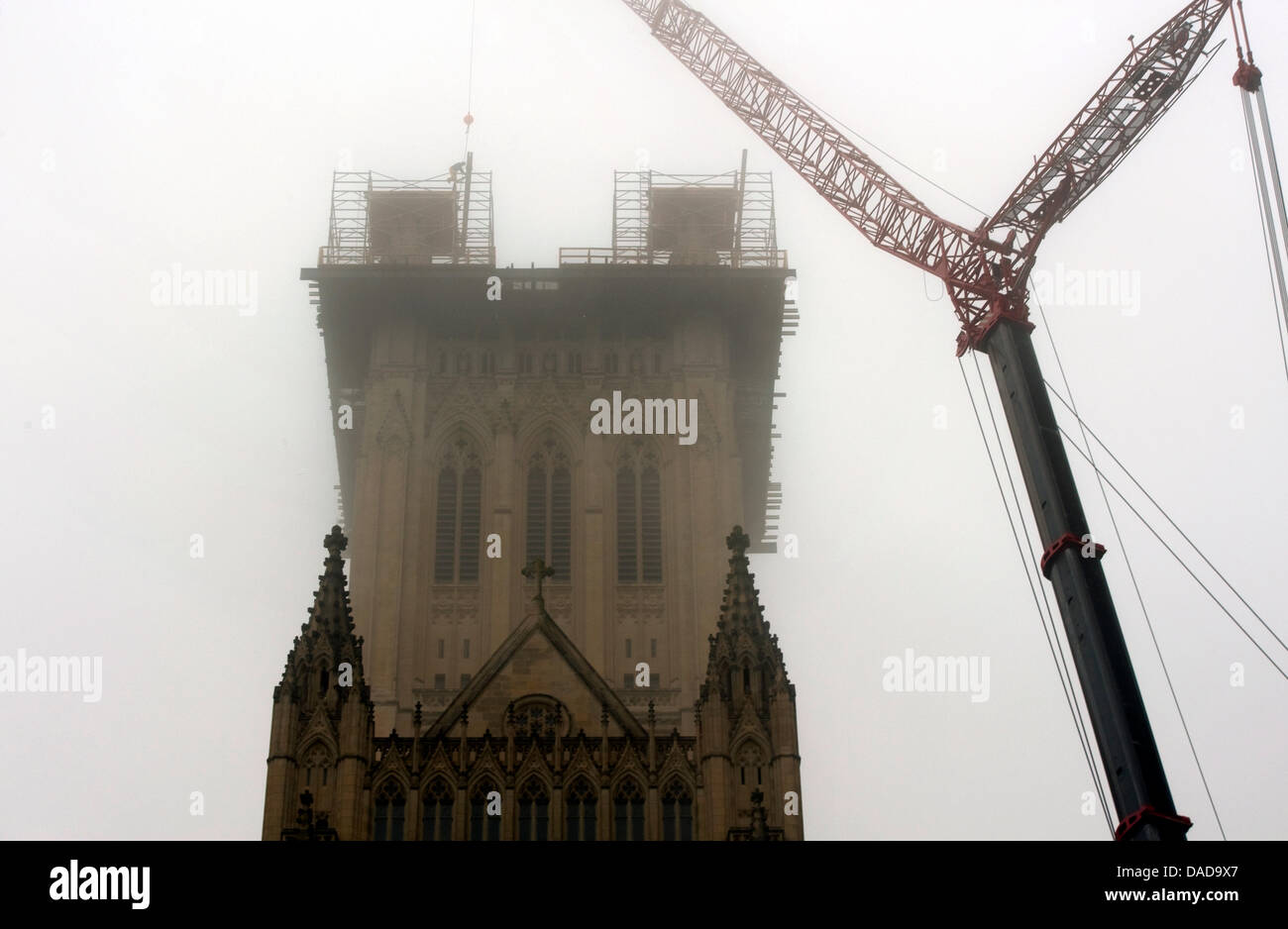 The central tower of the Washington National Cathedral is shrouded in fog as a worker secures a beam on the of the southwest grand pinnacle, in Washington, D.C., on Thursday, October 13, 2011. The Cathedral's central tower pinnacles were damaged by the magnitude 5.8 earthquake that struck the East Coast on August 23. The damaged portions of pinnacles are being removed to make the p Stock Photo