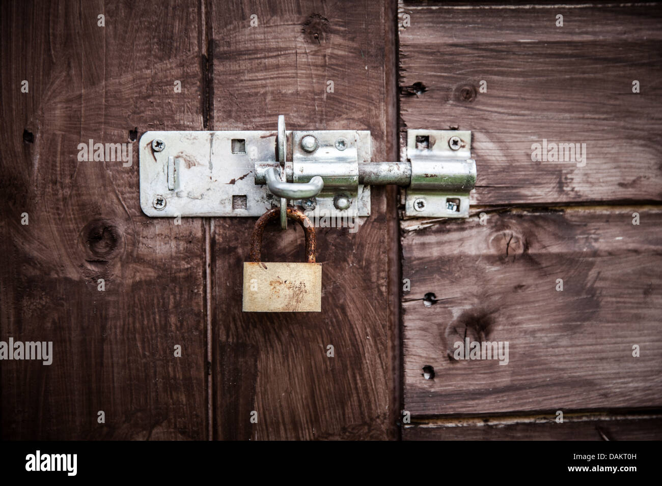 Rusty lock on wooden gate Stock Photo