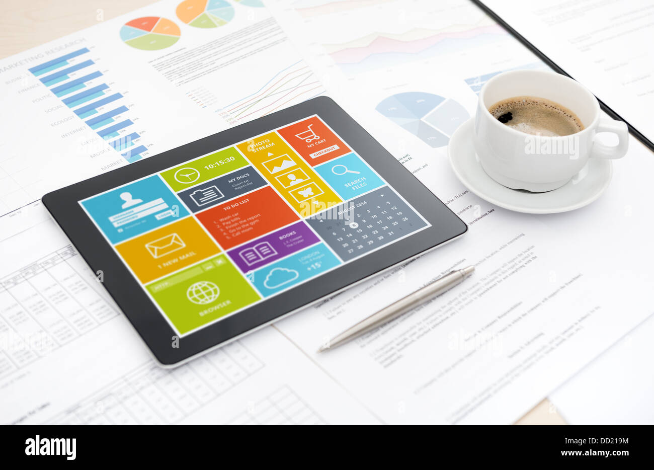 Modern digital tablet with modern user interface on screen lying on a desk with some papers and document, pen and cup of coffee. Stock Photo