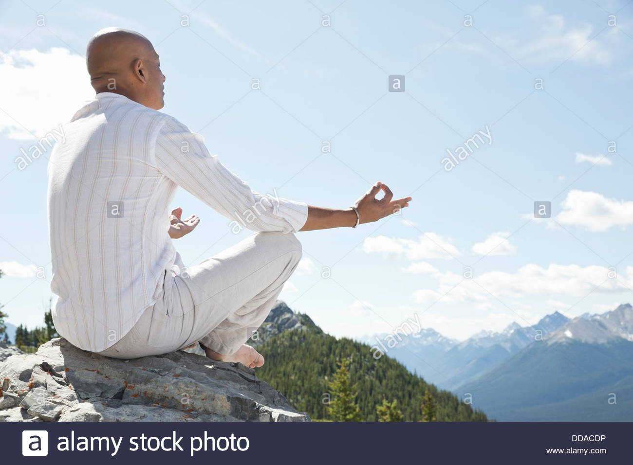 Mature Man Meditating On Mountain Top Stock Photo - Alamy