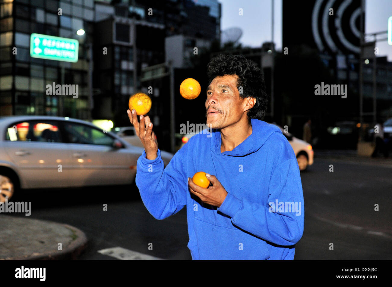 Poor man juggling with oranges at an intersection, Ciudad de Mexico, Mexico, Central America Stock Photo