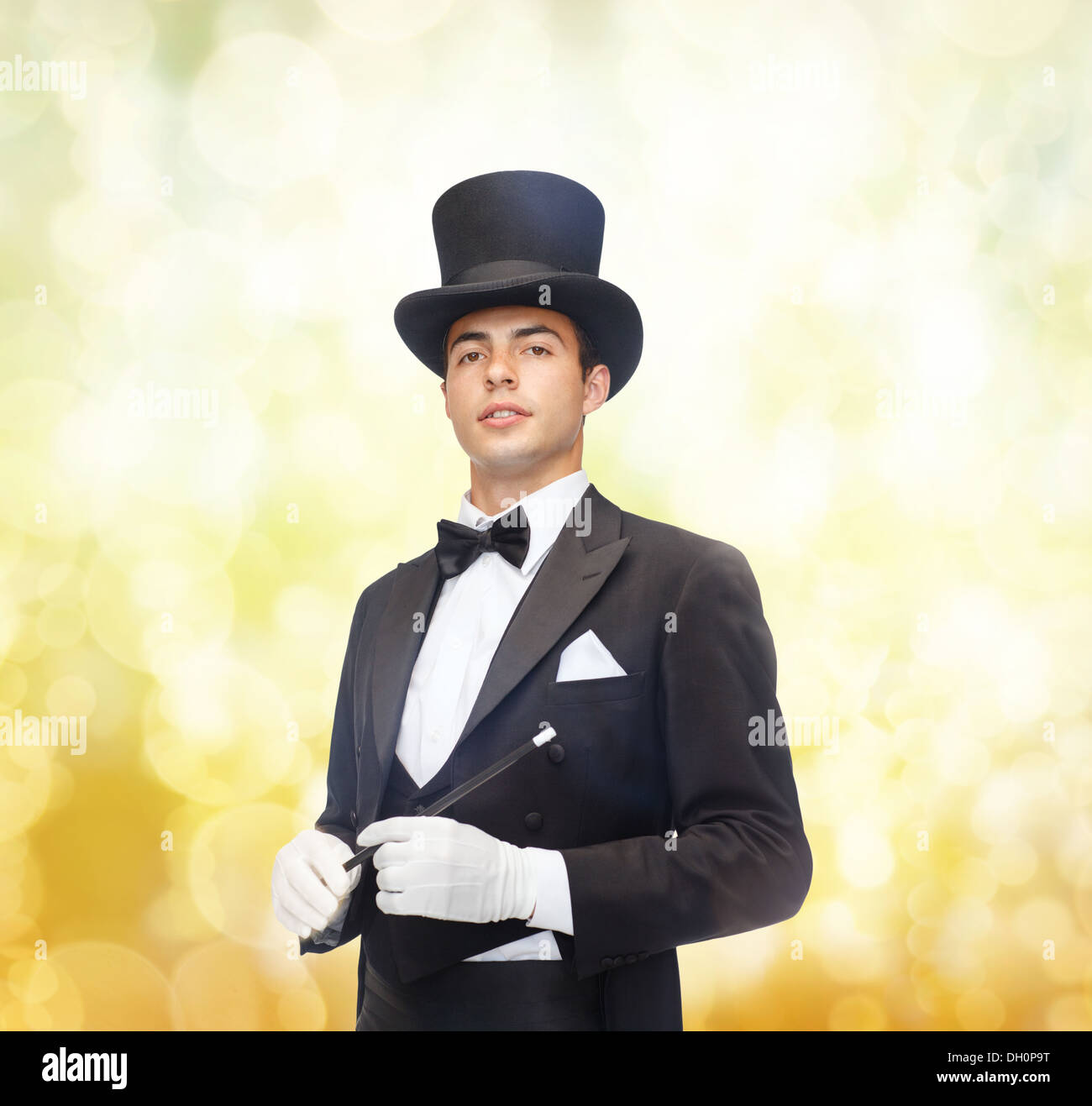 magician in top hat with magic wand showing trick Stock Photo