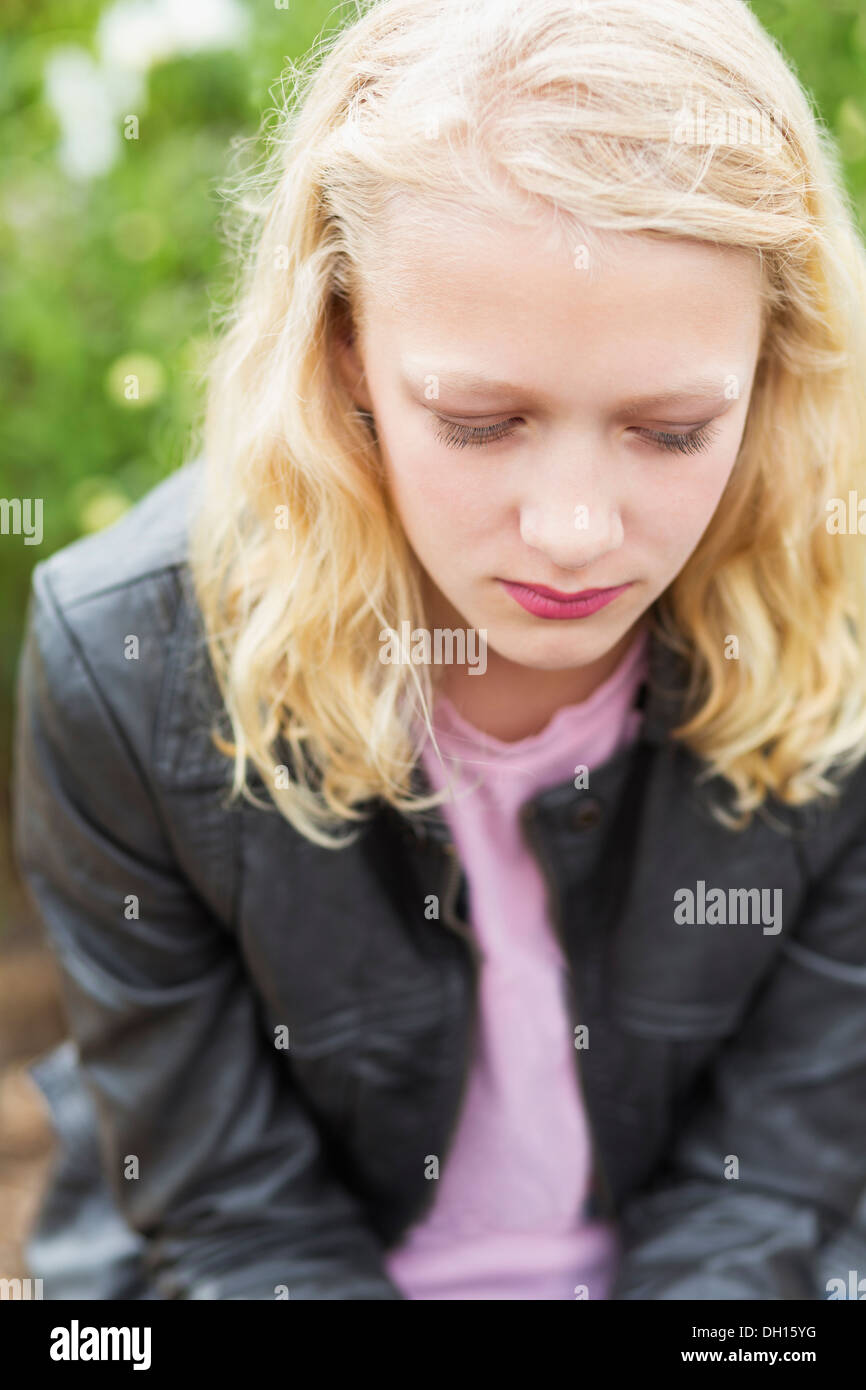 Caucasian girl sitting outdoors Stock Photo