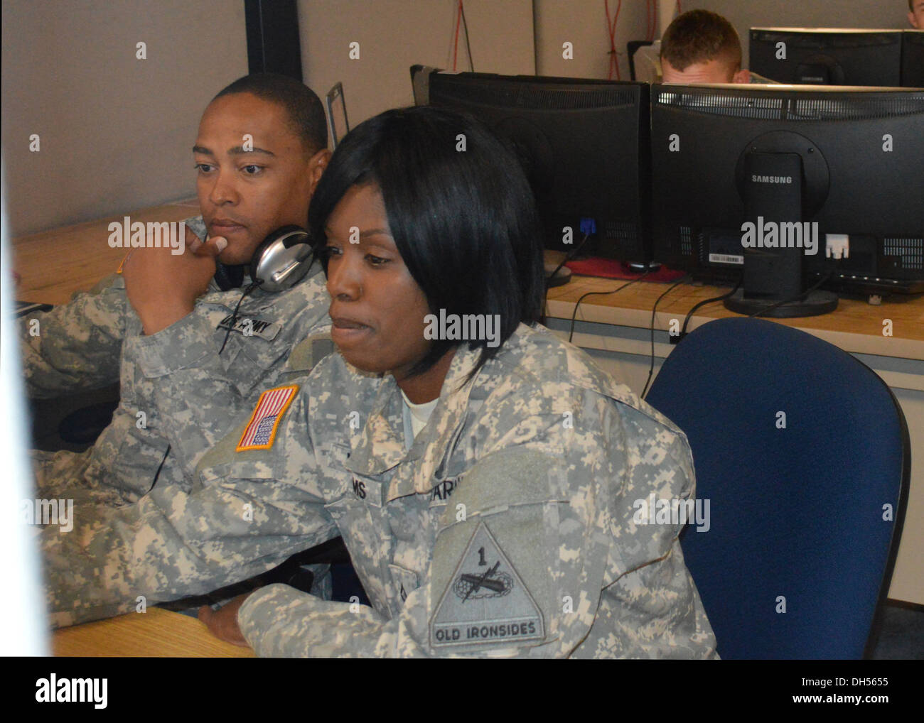 Spc. Steven V. Tyler (left), a Wheeled Vehicle Mechanic and Pfc. Kristy Williams, Signal Support Systems Specialist, both with 1st Squadron, 1st Cavalry Regiment monitor and execute moves on the simulation computers as well as monitor commands coming over Stock Photo