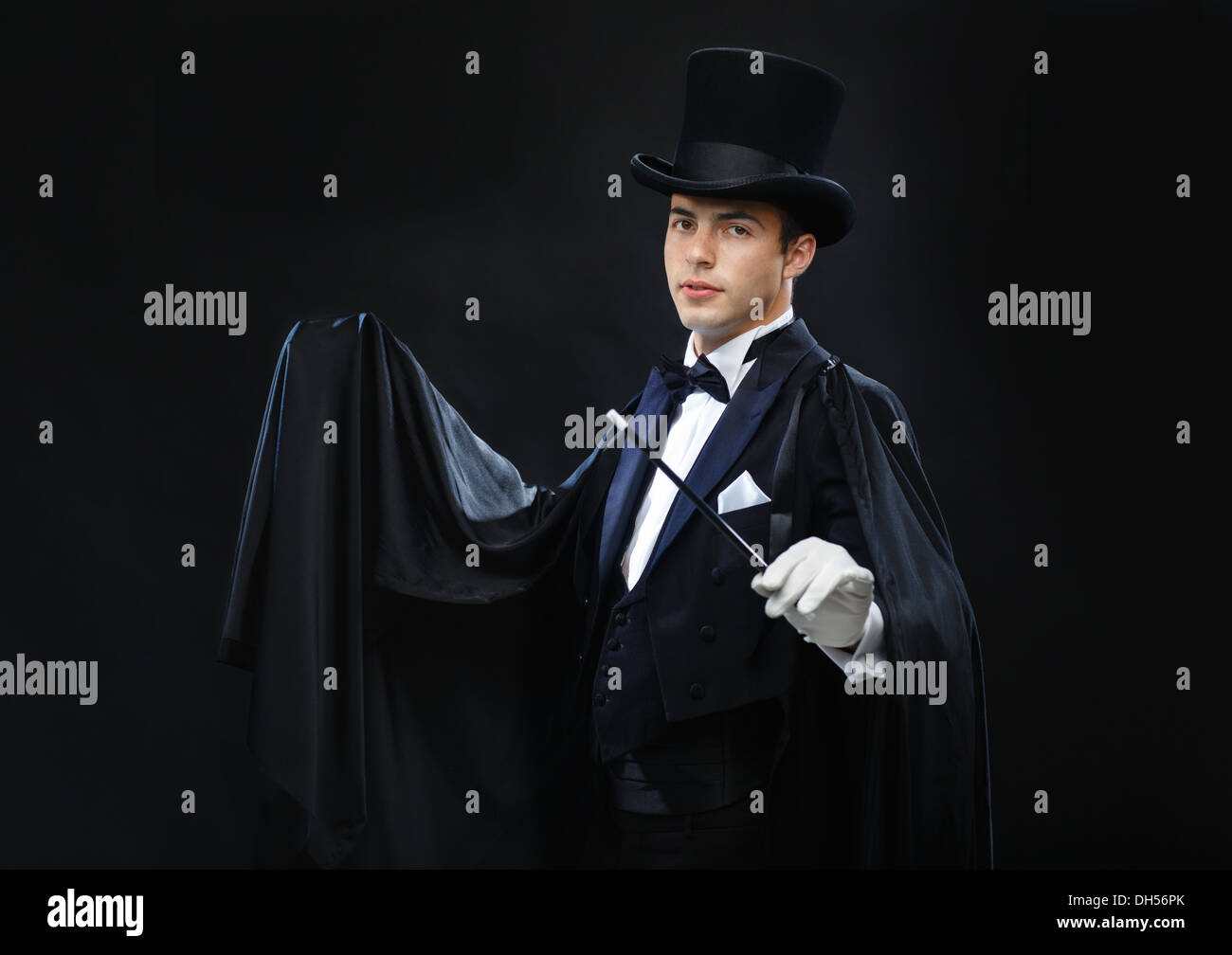 magician in top hat with magic wand showing trick Stock Photo