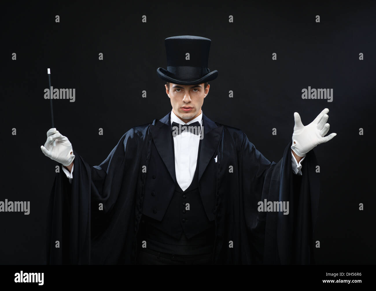 magician in top hat with magic wand showing trick Stock Photo