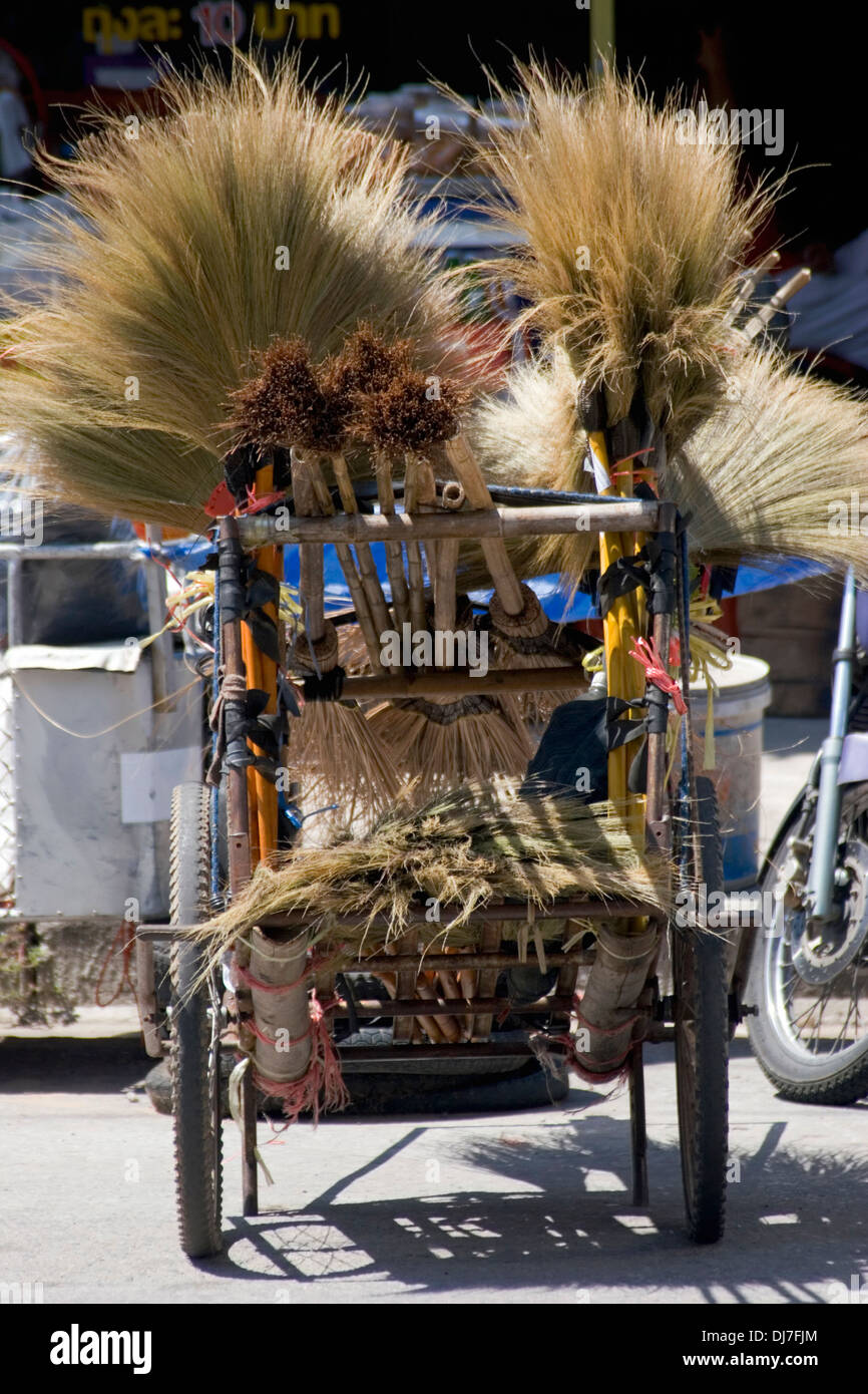 A cart filled with handmade brooms that are for sale rests on a city street in Khon Kaen, Thailand. Stock Photo