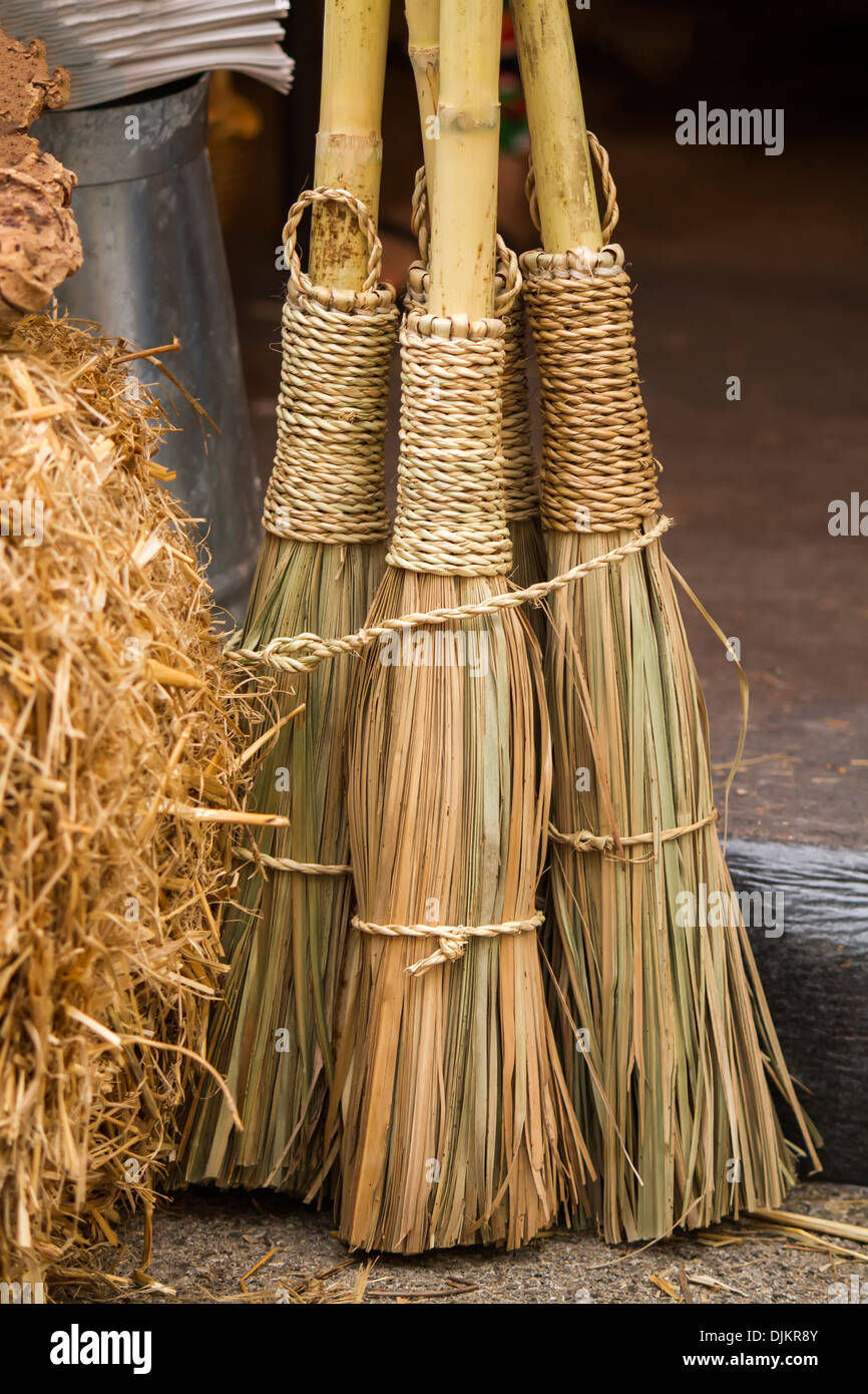 Close view of some straw brooms. Stock Photo