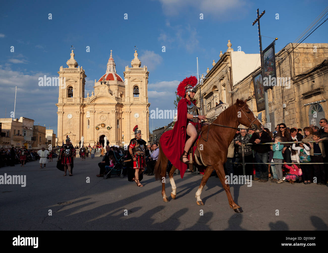 A man dressed as a Roman soldier on horseback parades through the streets of town during a reenactment of Good Friday in Malta. Stock Photo