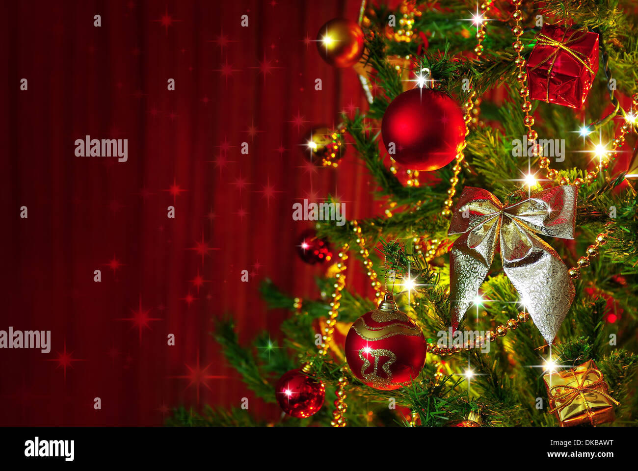 Detail of a Christmas tree next to red window curtains with copy space Stock Photo