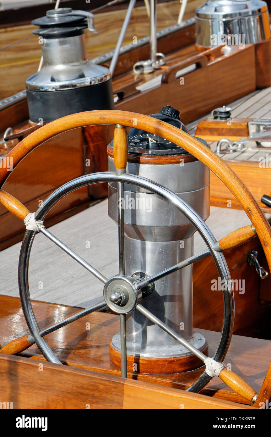 Detail of an old-fashioned boat deck with rudder, compass and other navigation tools Stock Photo