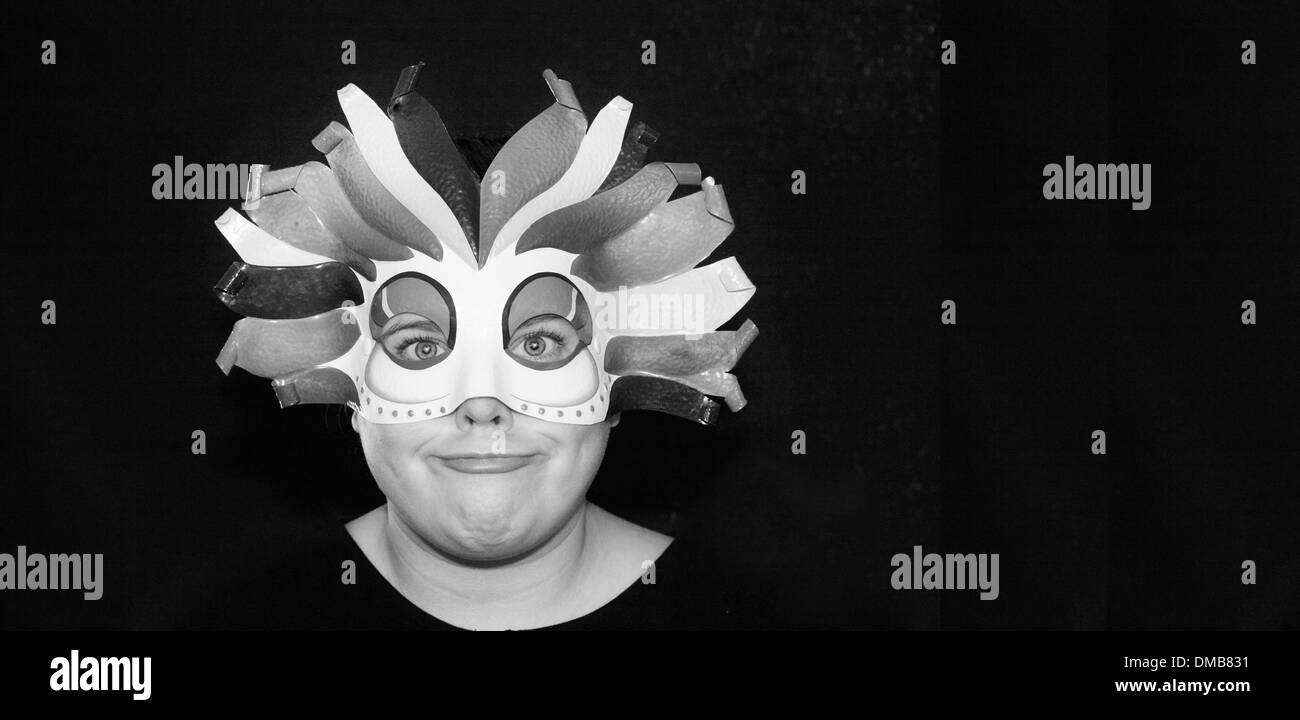 Girl in a harlequin mask with a funny look on her face. Stock Photo