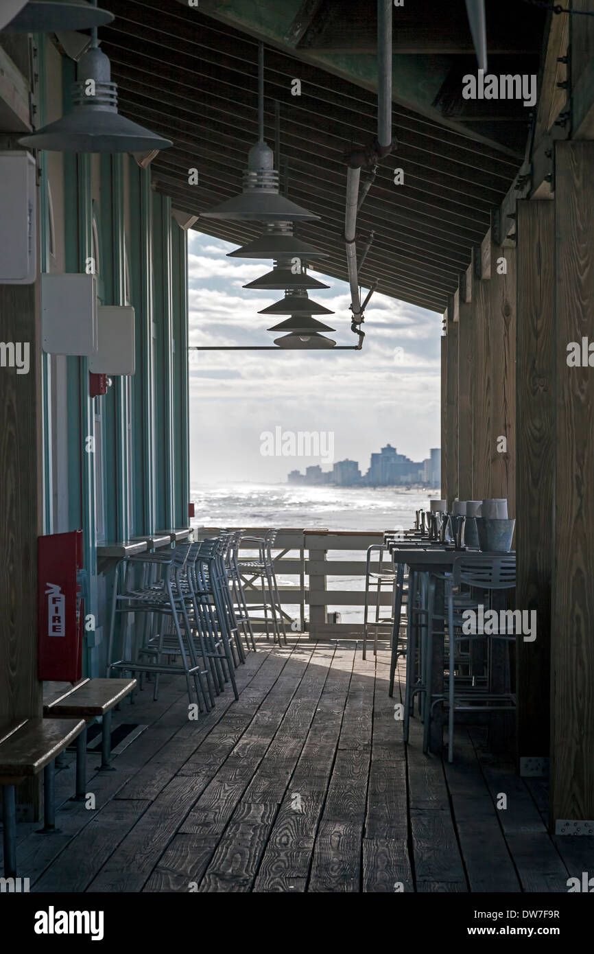 Outside restaurant seating on the fishing pier in Daytona Beach, Florida enjoys beautiful views of the Atlantic coastline, USA. Stock Photo