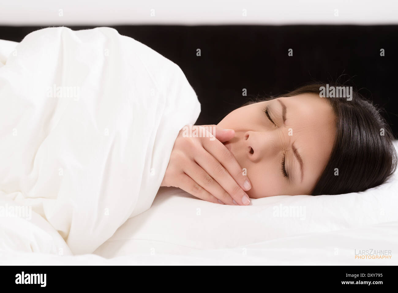 woman in bed yawning Stock Photo