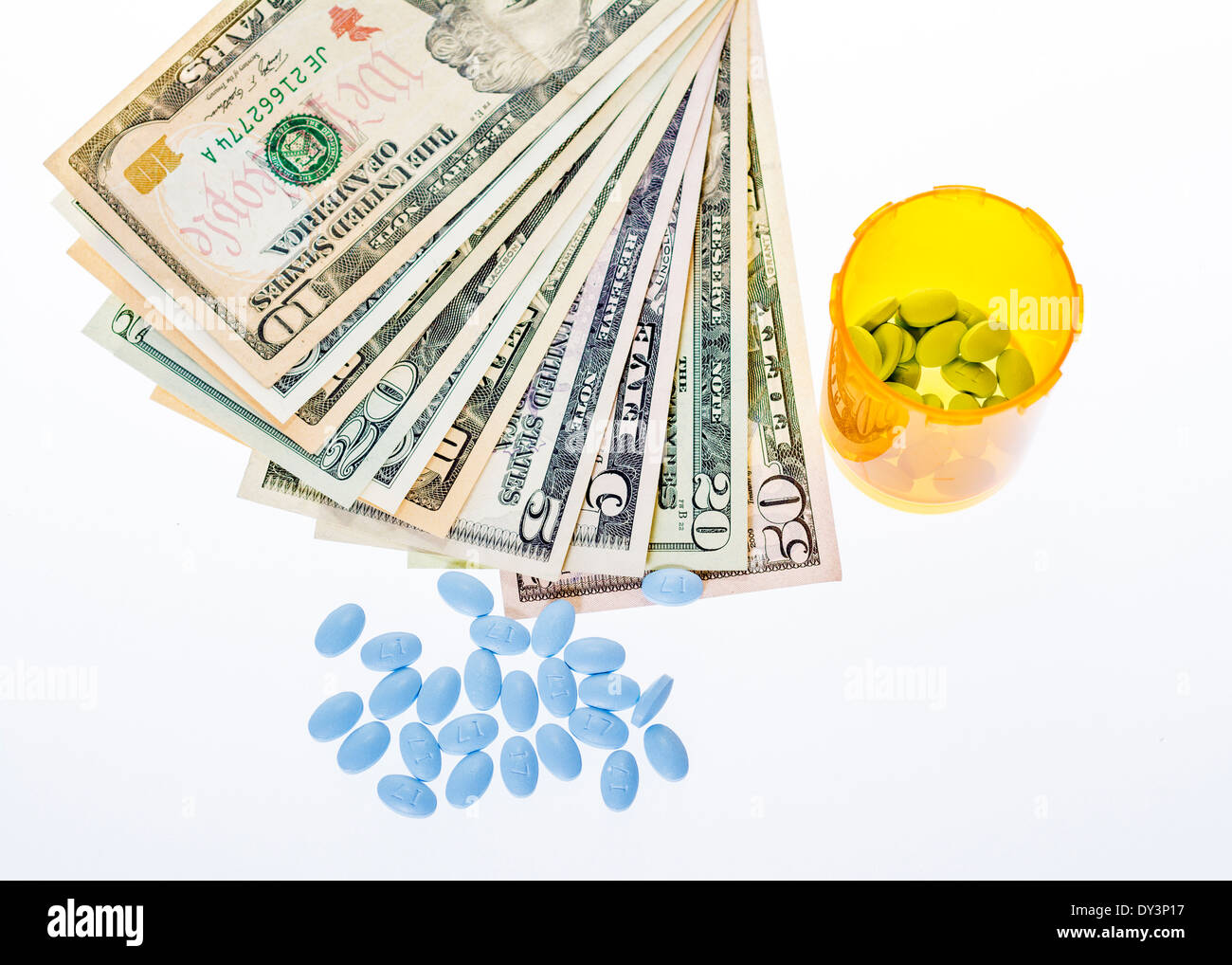 Little blue pills and pile of cash Stock Photo