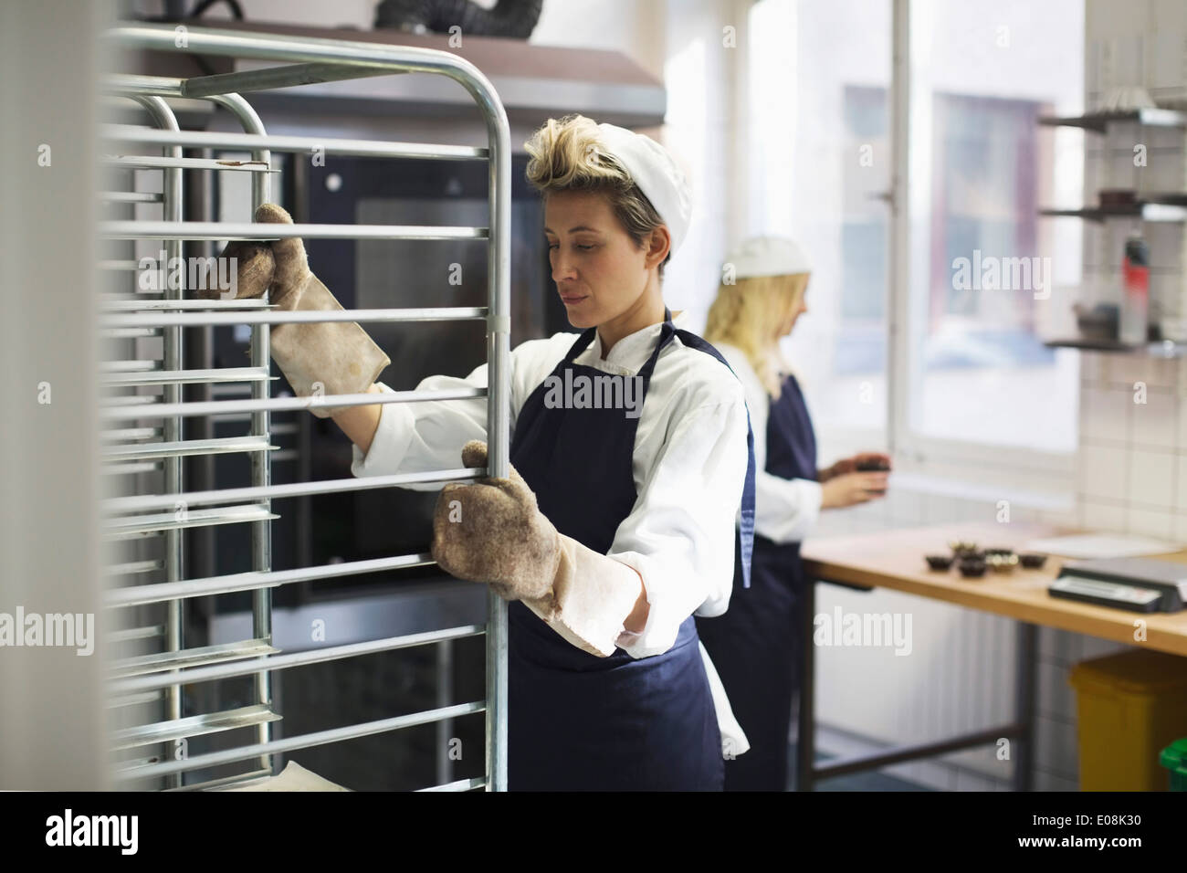 Female baker working in kitchen at bakery Stock Photo