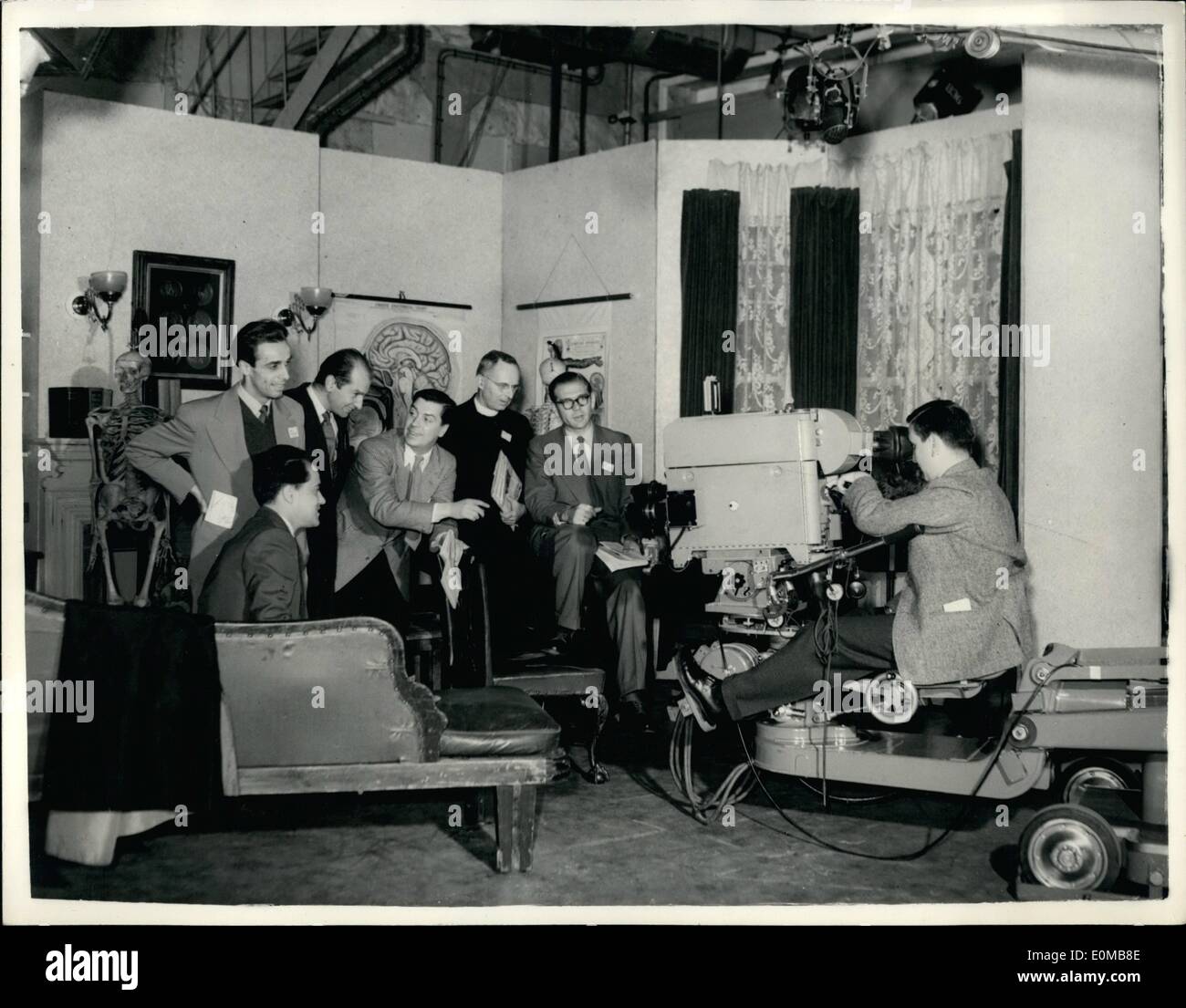 Jul. 07, 1954 - Television experts from ten countries visit lime grove studios : Twenty - four television experts from ten countries who are in London for a three weeks TV study course at the expense of UNESCO - the united nations educational scientific and Cultural organization - today paid a visit to the lime grove TV studios. photo shows Royston Morley.,chief editor of TV training (leaning on chair) describes technical details of a TV stage setting to vaous members of the party which includes TV experts from U.s. japan France and Italy, seen seated at the TV camera is Mr Stock Photo