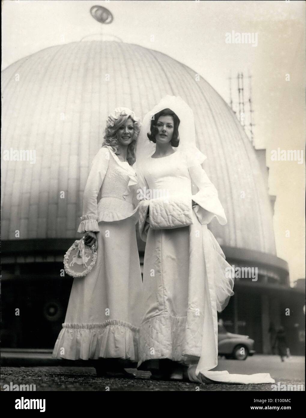 Feb. 02, 1972 - Horoscope collection of wedding dresses by youngs dress hire.: Star models Vicki Hodge and Jackie Craven were outside the Planetarium in Baker Street today, to launch,appropriately enough, the Horoscope collection of wedding dress for the starry-eyed brides of 1972 by Young Dress Hire. Wearing galaxy make-up motifs and carrying symbols of the Zodiac, Vicki and Jackie showed off six of the twelve styles in the range - Aquarius, Pisces, Taurus, Gimini and Cancer. Photo shows model Vicki Hodge (left) wear's 'Taurus' - dress in silk poult with peplum waistline Stock Photo