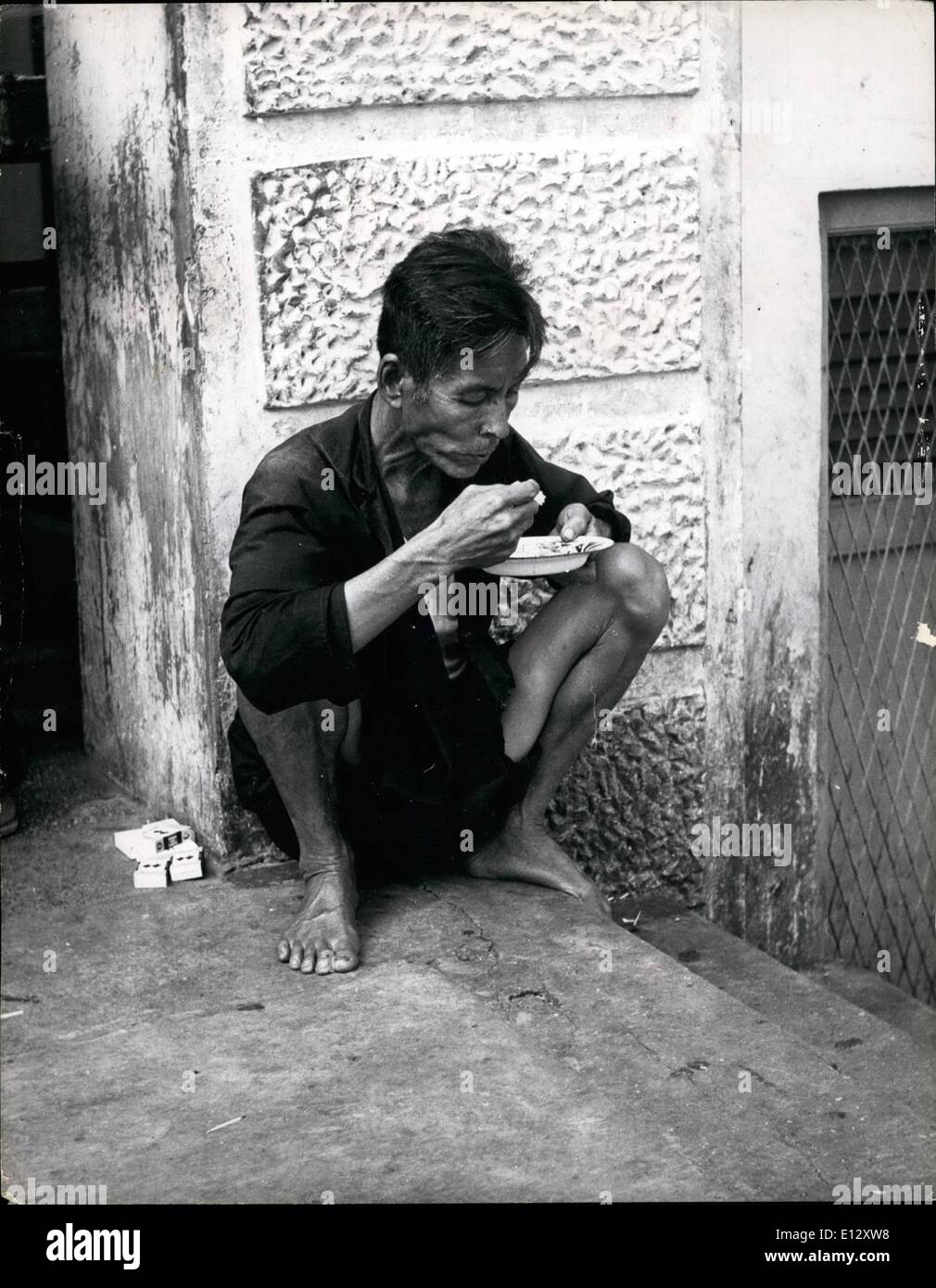 Feb. 25, 2012 - How a poor man eats in Singapore: A coolie squats in the street and eats his rice. Will Singapore get independence in 1957. Another British Possession on the Threshold of a new Era: ''Merdeka'' (independence for Singapore) may come this year, with the granting of a new constitution for internal independence, obtained by Lim Yew Hock, Chief Minister of the colony founded by Sir Stamford Raffles on a marsh in 1819 for the then East India Company Stock Photo