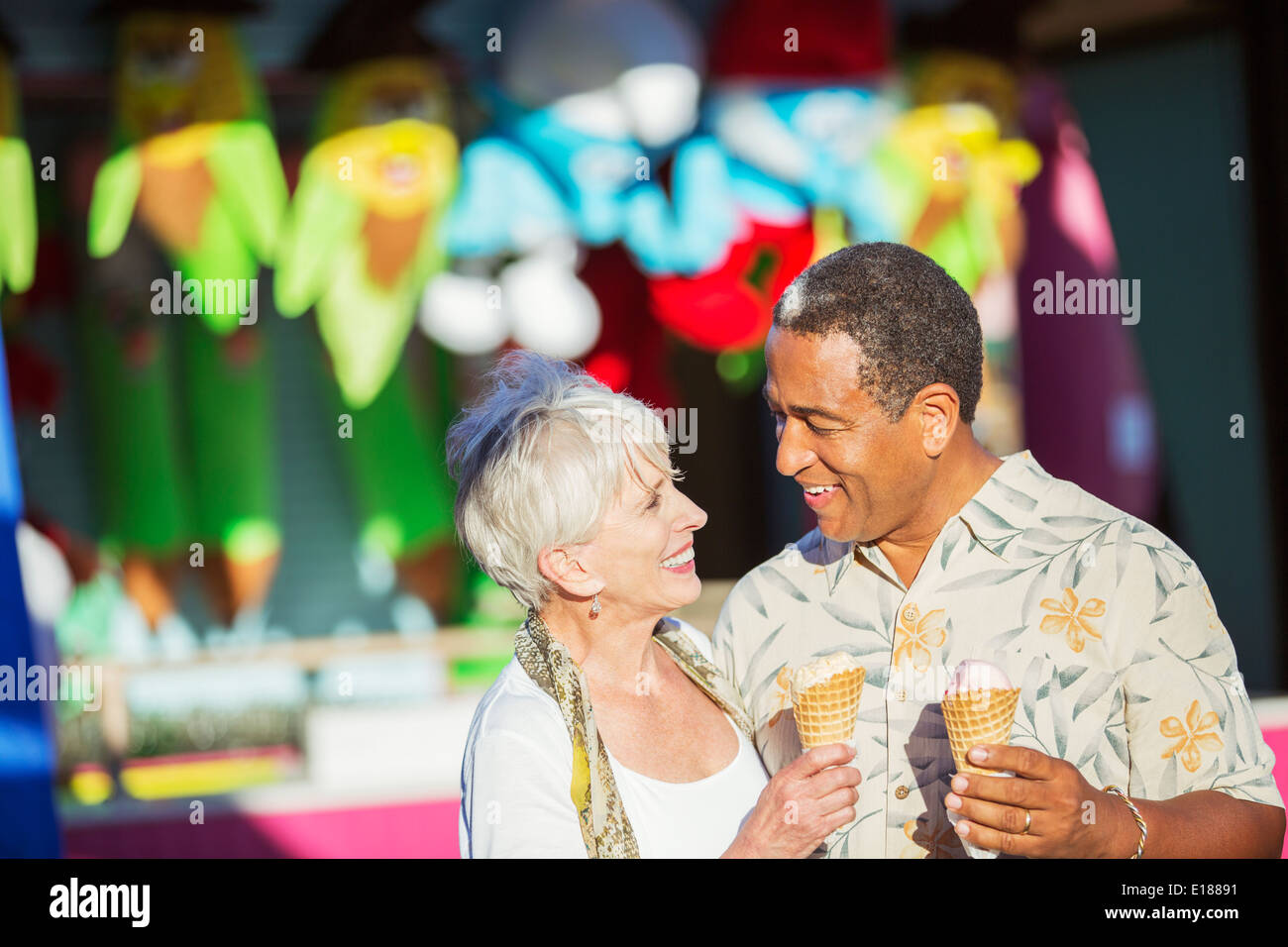 Senior couple eating ice cream cones at amusement park Stock Photo