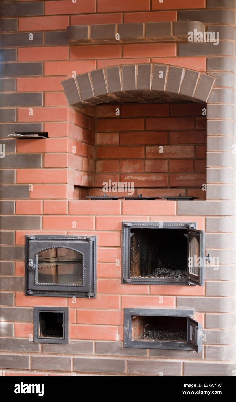 brick facade closeup of big house stove with metal doors and decorated cooker Stock Photo