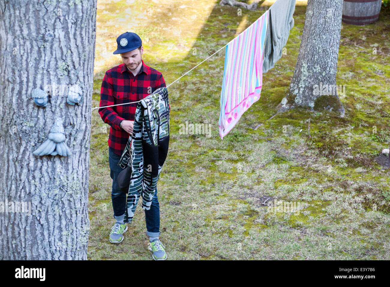 High angle view of mid adult man hanging out laundry in garden Stock Photo