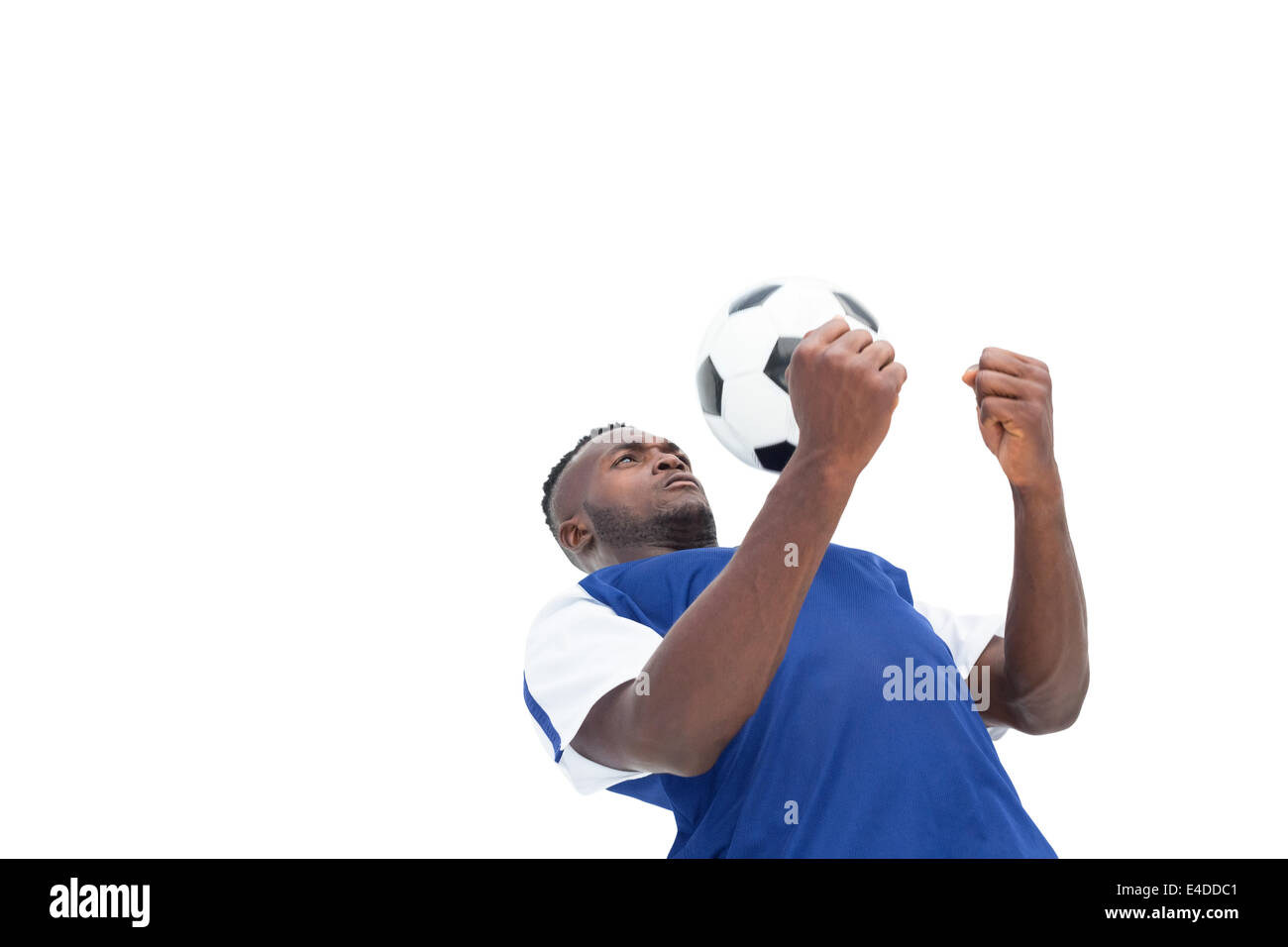 Football player in blue jersey controlling ball Stock Photo