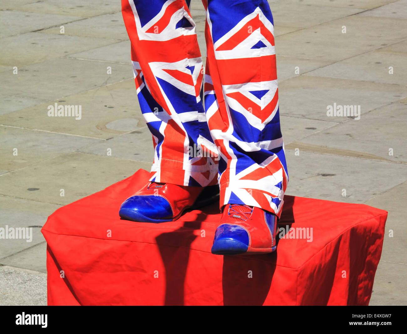 Street performer wearing trousers and shoes of the Union Jack flag of the UK in London, England Stock Photo