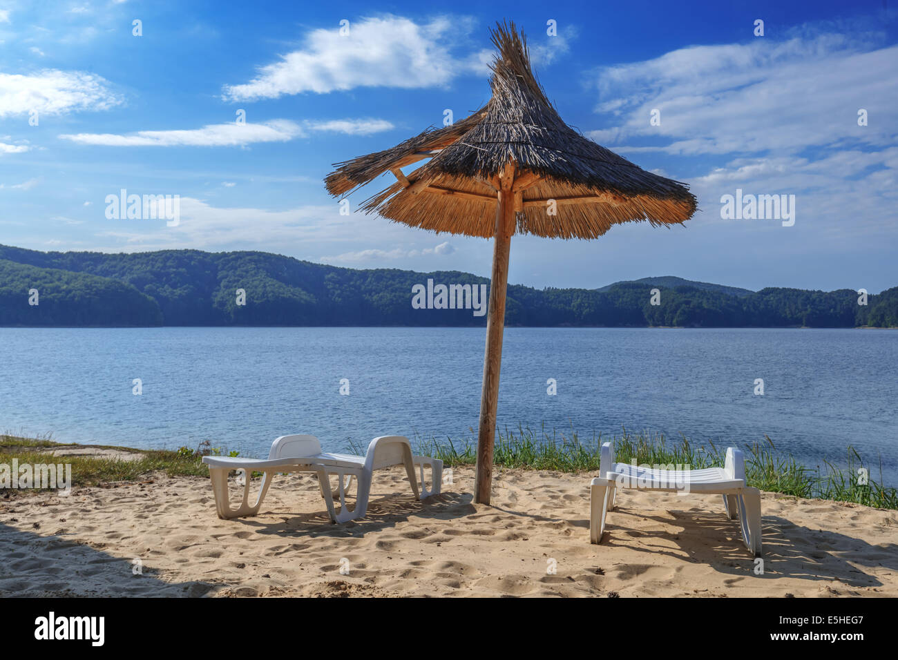 deck-chair and parasol on beach Stock Photo