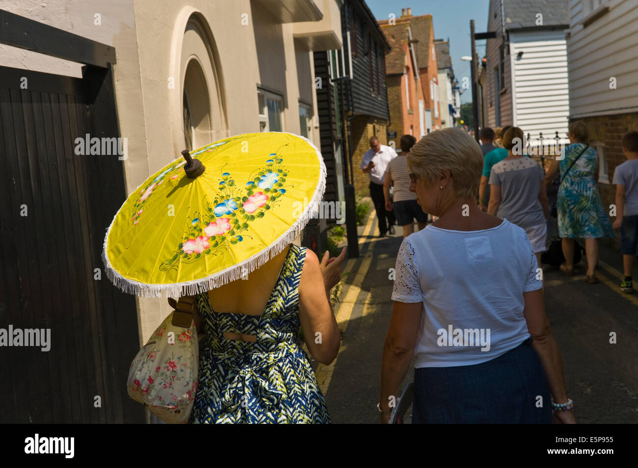 Woman using parasol umbrella as shade during Whitstable Oyster Festival Kent England UK Stock Photo