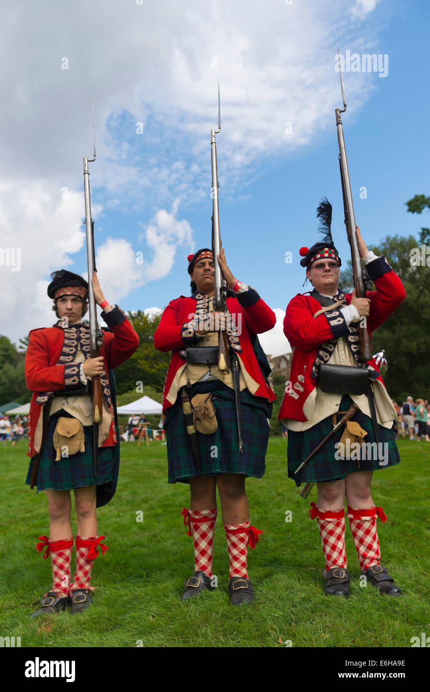 Old Westbury, New York, U.S. - August 23, 2014 - L-R, TIM NORTON, of CT, AARON BOATRIGHT, of CT, and CONRAD BENDER IV, of NJ, are American Revolution re-enactors portraying members of the 42nd Royal Regiment of Foote, at the 54th Annual Long Island Scottish Festival and Highland Games, co-hosted by L. I. Scottish Clan MacDuff, at Old Westbury Gardens. The regiment, The Black Watch, was raised in the Scottish Highlands in 1740 and fought for the British. Credit:  Ann E Parry/Alamy Live News Stock Photo