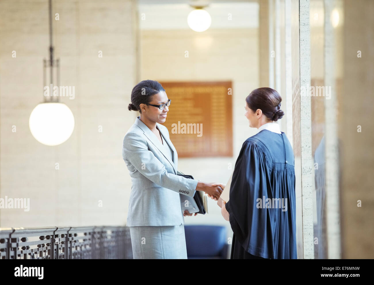 Judge and lawyer shaking hands in courthouse Stock Photo