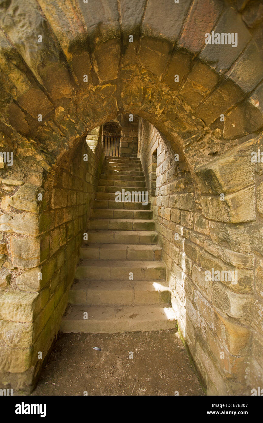 Stone archway with narrow passage and steps inside ruins of historic 12th century castle at Warkworth Northumberland, England Stock Photo