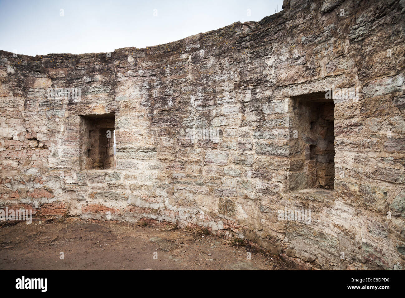 Round ruined interior with empty windows of old stone fort tower. Koporye Fortress, Leningrad Oblast, Russia Stock Photo