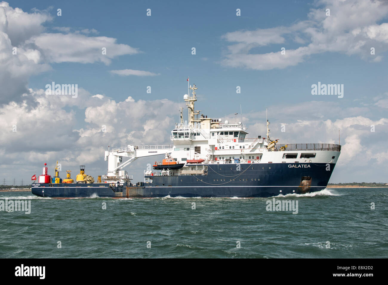 Trinity House multi functional tender Galatea makes her way along the Solent with a selection of maritime buoys onboard. Stock Photo