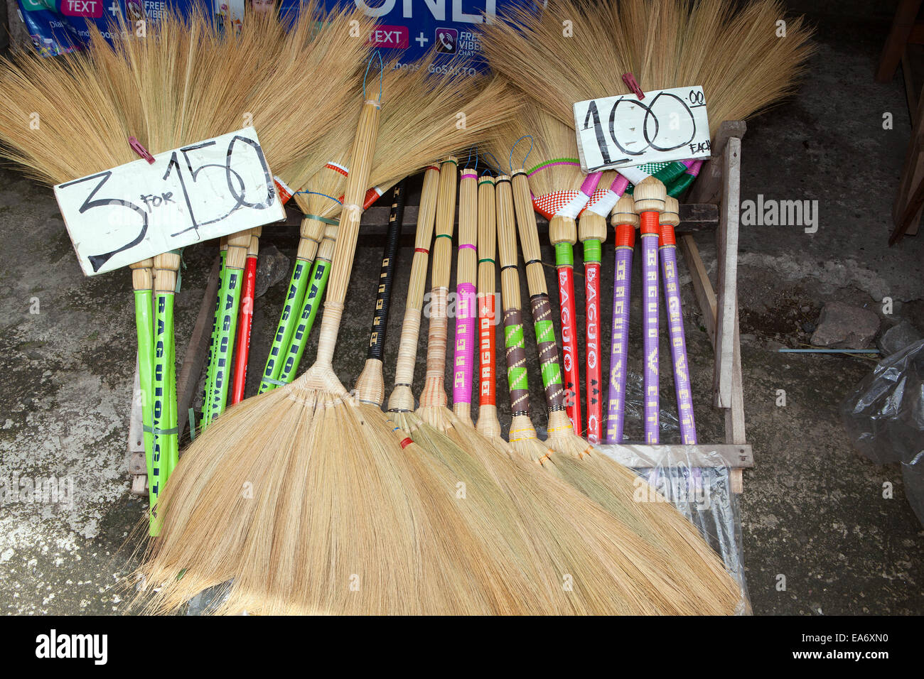 Colorful handmade straw souvenir fan brooms for sale at a roadside stand in Baguio City, Luzon Island, Philippines. Stock Photo