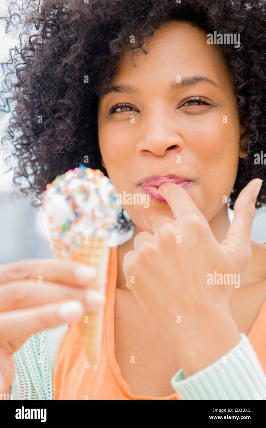 Smiling woman eating ice cream cone Stock Photo