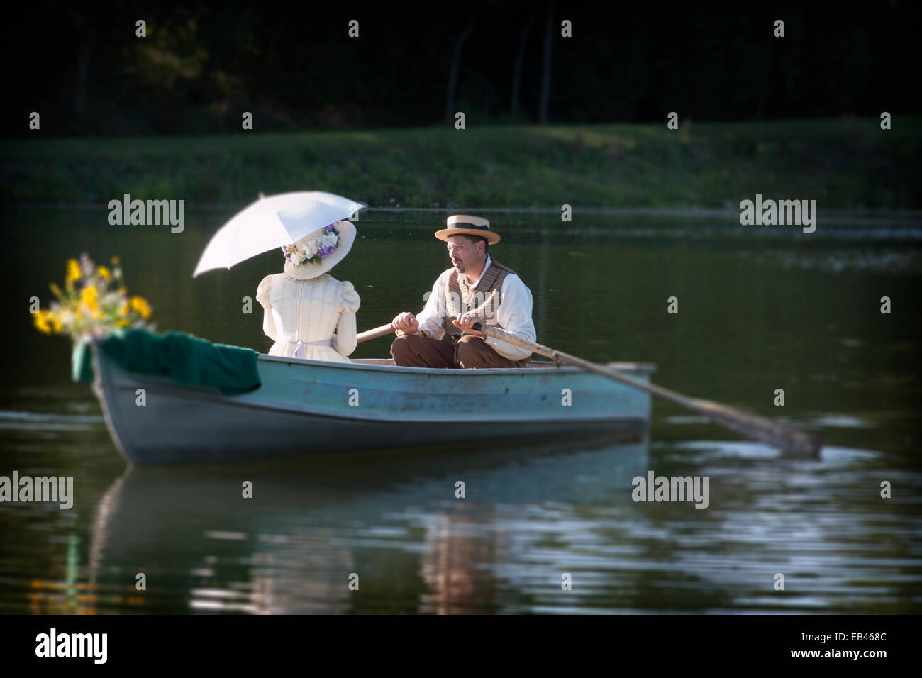 An Old Fashioned couple rowing a boat on a date Stock Photo