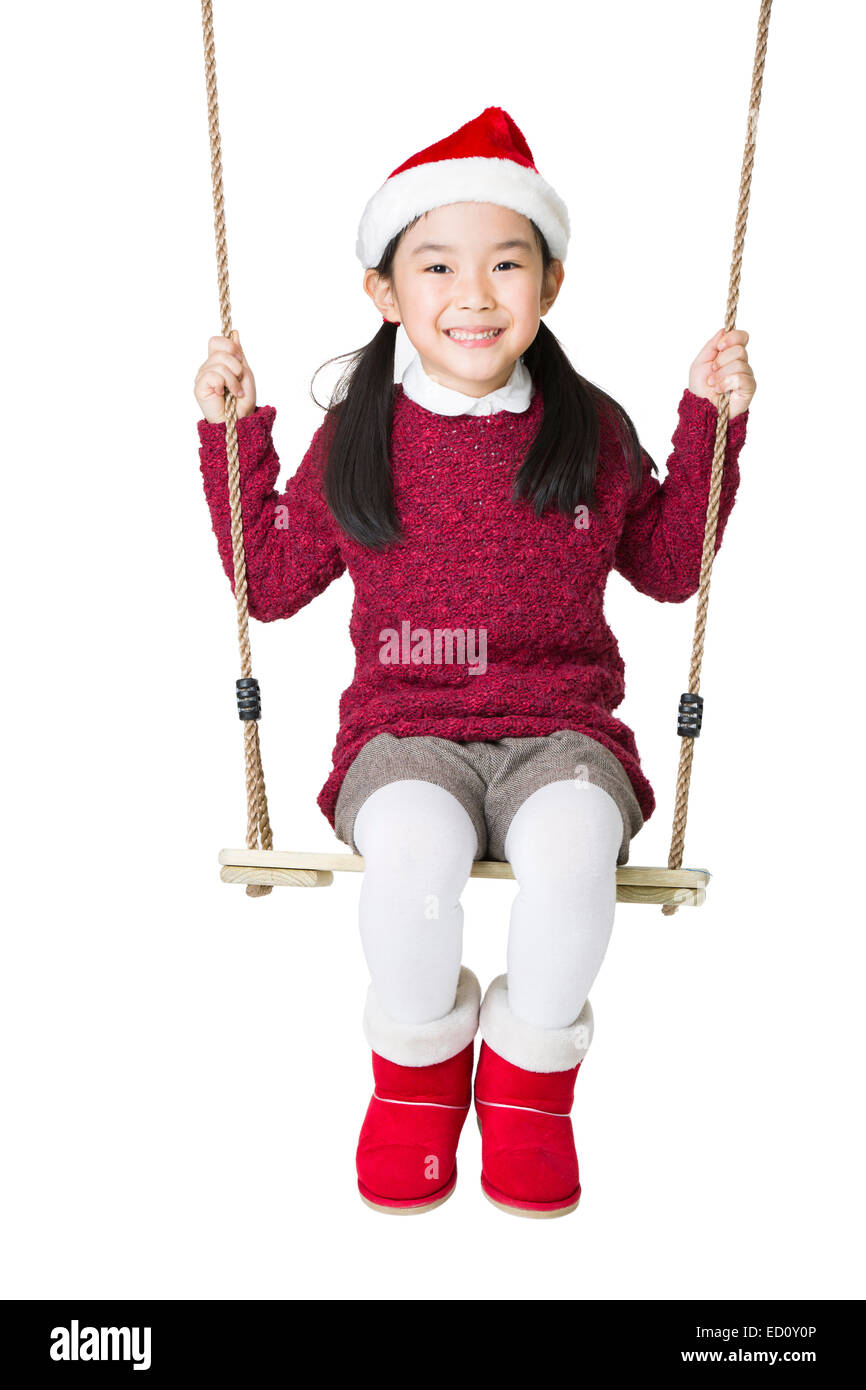 Happy girl in Santa hat on swing Stock Photo