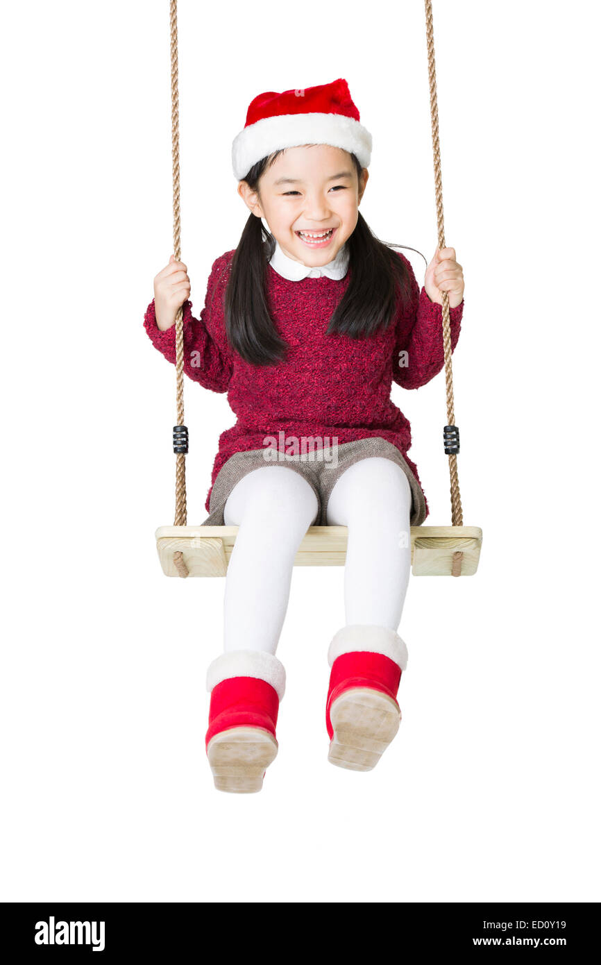 Happy girl in Santa hat on swing Stock Photo