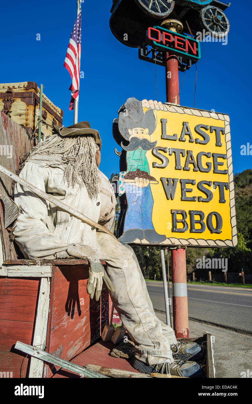 Dummy stage coach driver seated on the driver's seat of an old stage coach in a display of the old west outside of a restaurant Stock Photo