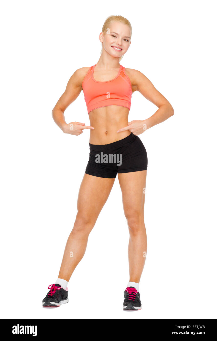 smiling sporty woman pointing at her six pack Stock Photo