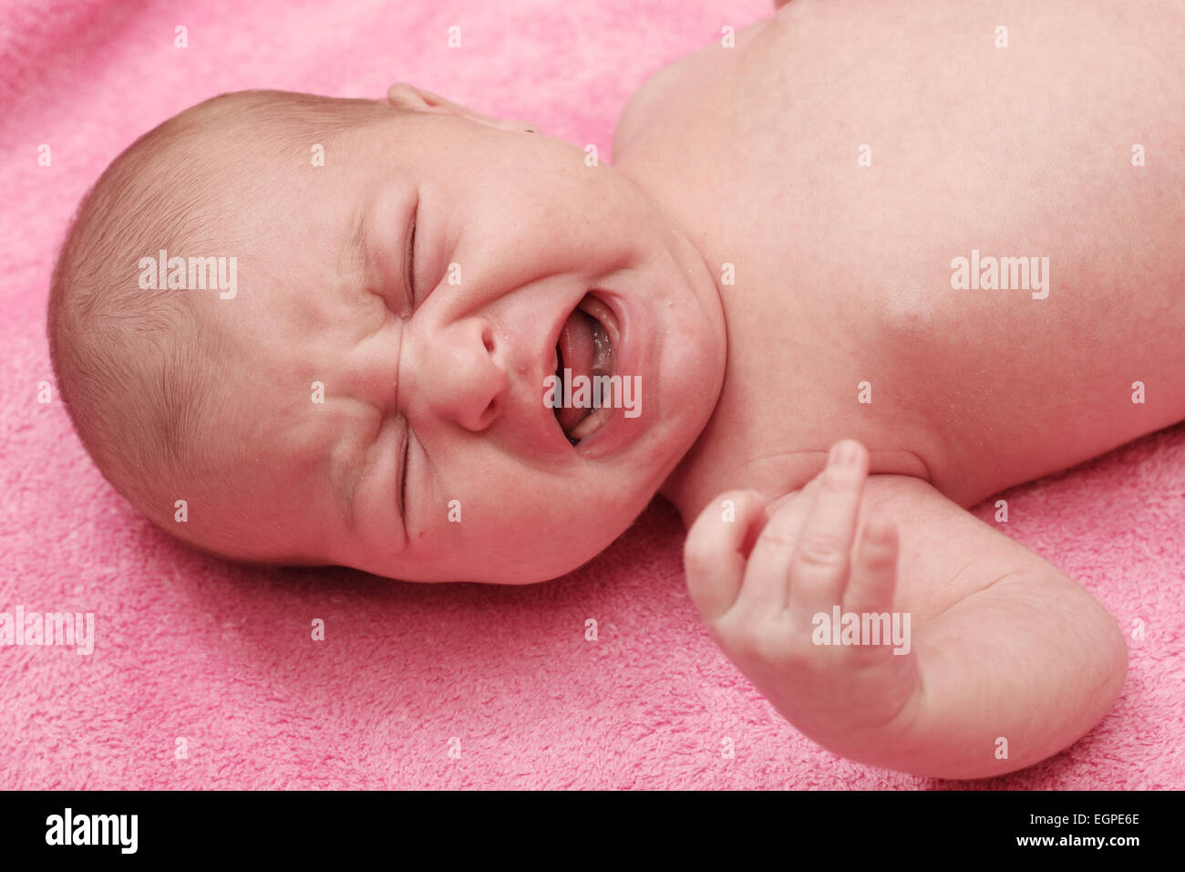 beautiful baby crying on a pink background Stock Photo