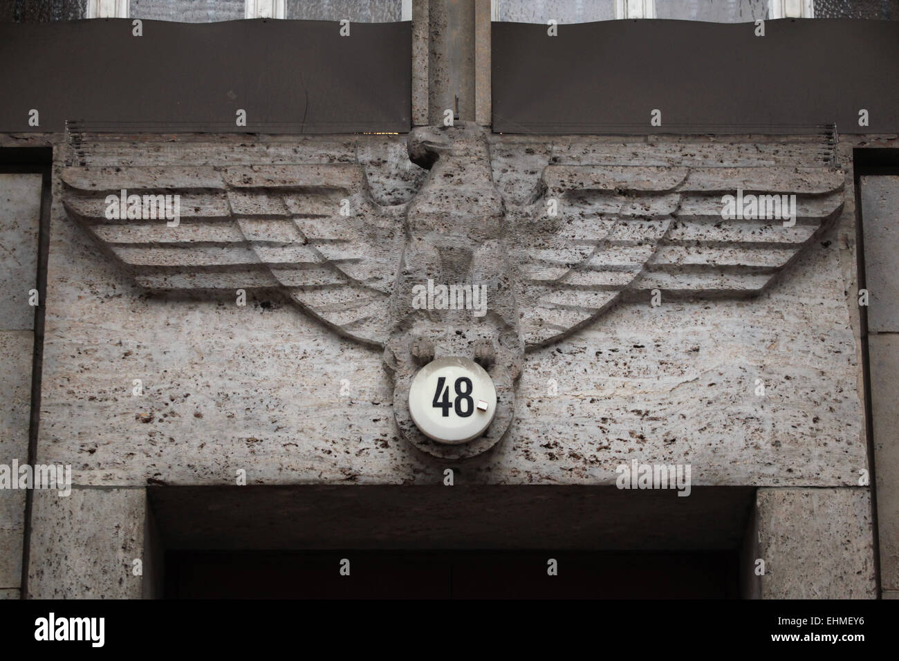 Reichsadler by German sculptor Kurt Schmid-Ehmen over the doorway of the Finanzamt Charlottenburg in Berlin, Germany. Swastika is covered by the address number. The building at Bismarckstraße 48 designed by German architect Heinrich Wolff was built from 1934 to 1940 as the State Bank (Reichsbank), now the Finanzamt Charlottenburg. Stock Photo